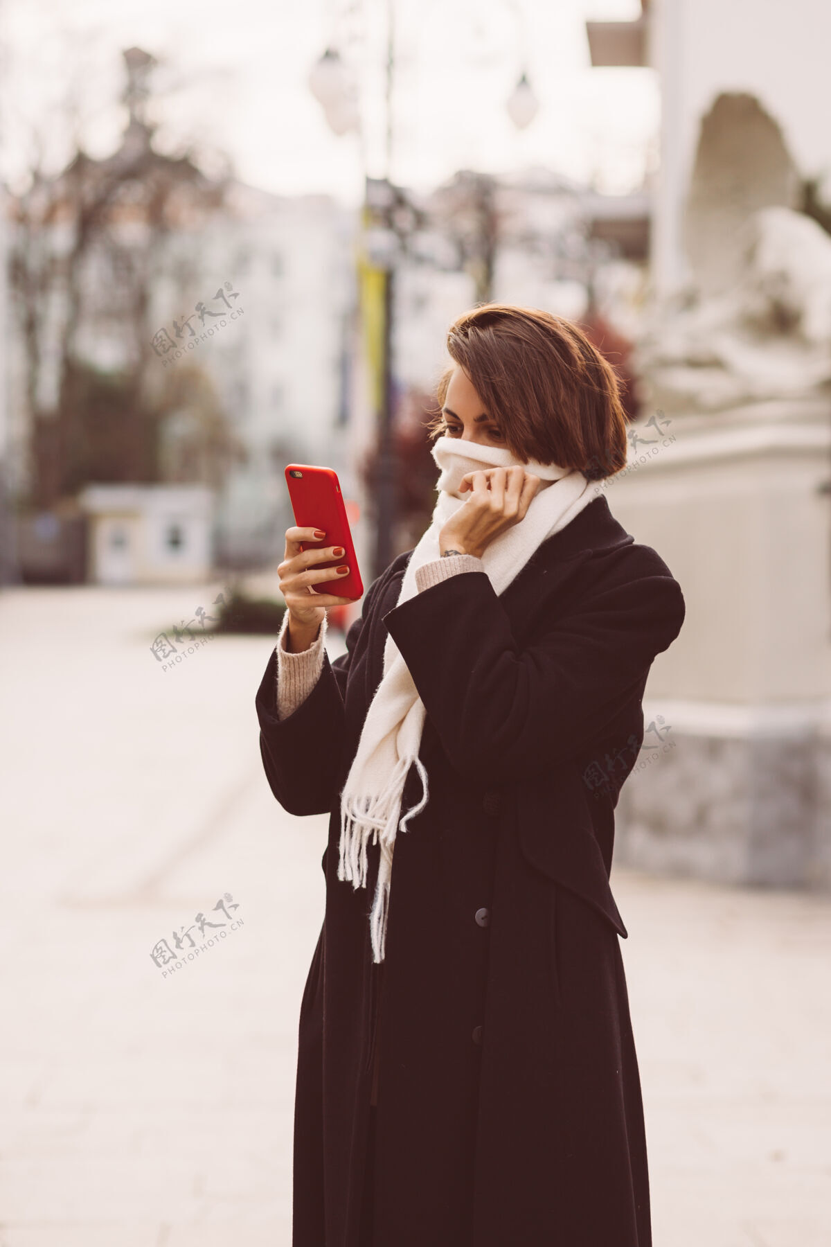 外套街上穿着黑色冬衣 戴着白色围巾 手持手机的女人的户外写真电子邮件户外成人