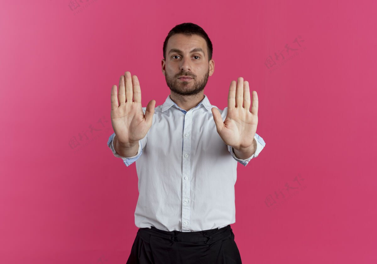 自信自信的帅哥在粉红色的墙上用两只手分别做手势停止手势伙计停帅哥
