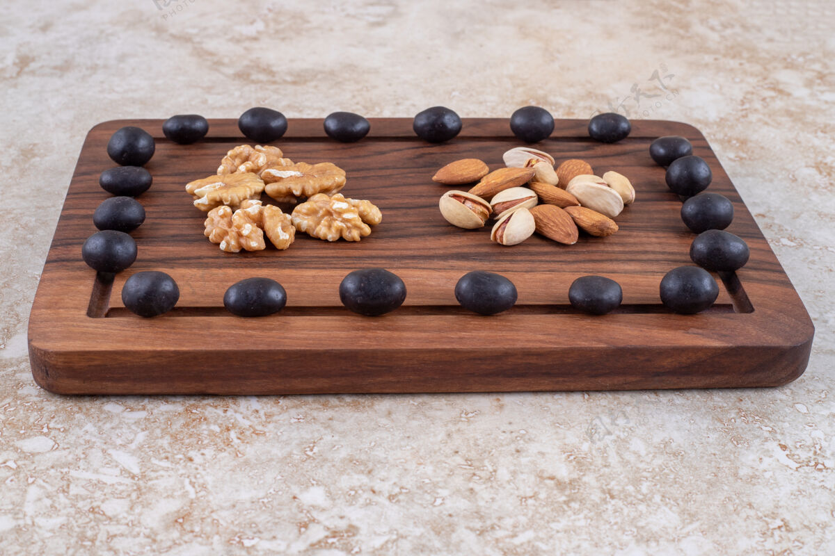 开心果巧克力糖果和坚果堆在一块木板上木板巧克力核桃