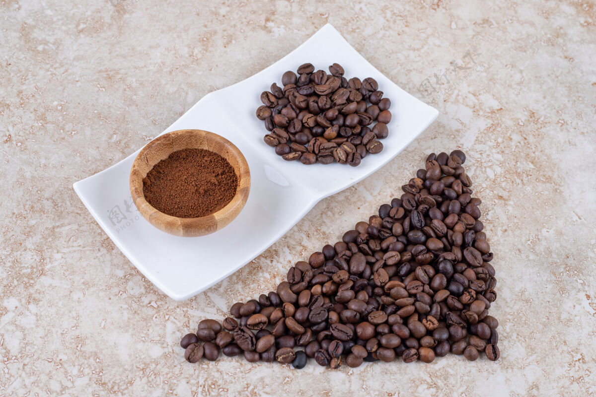 粉末咖啡豆堆和一小碗磨碎的咖啡碗芳香咖啡因