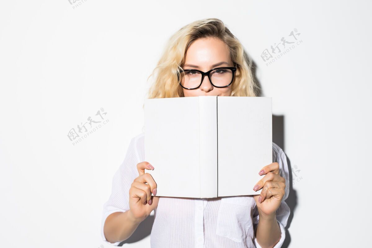 秘密一位年轻女商人的画像 她戴着眼镜躲在一本书后面 孤零零地躺在灰色的墙上脸情感可爱