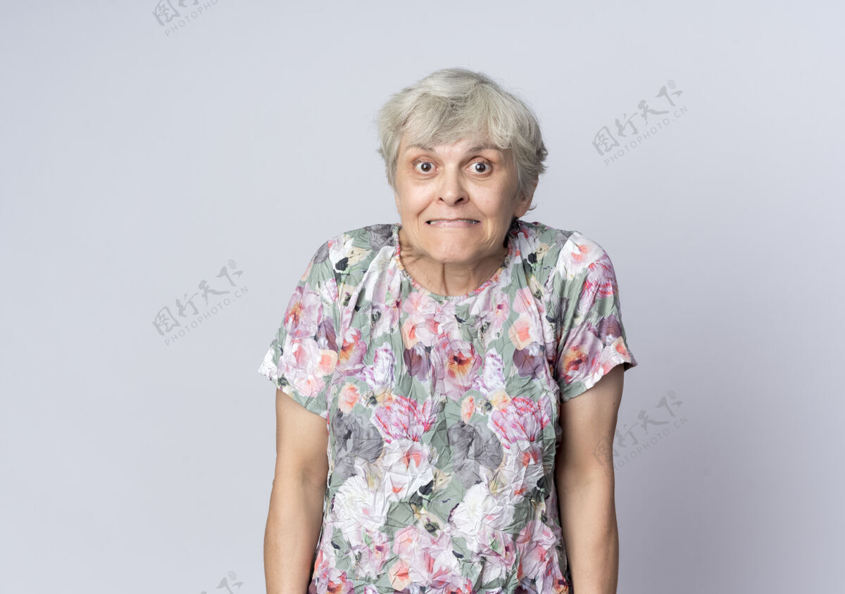 站着焦虑的老妇人孤零零地站在白墙上女人着急老人