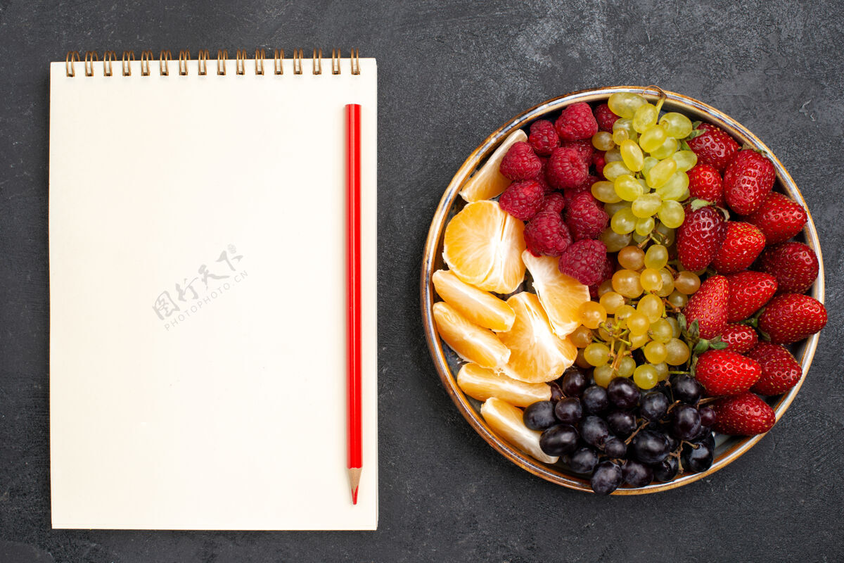 食品顶视图水果成分草莓葡萄覆盆子和柑橘托盘内的黑暗空间覆盆子内部水果