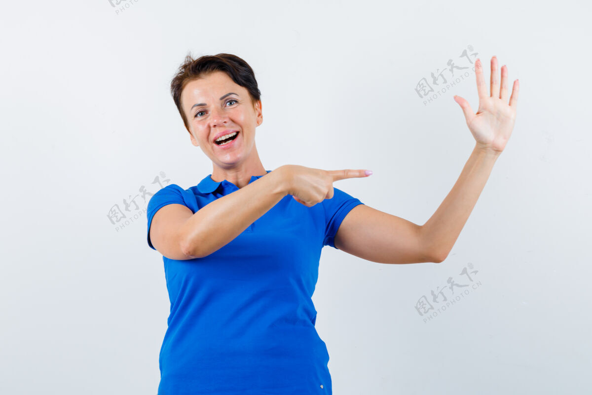年龄一幅成熟女人的画像 她指着她那穿着蓝色t恤的举起的手 看上去很自信人女士指尖