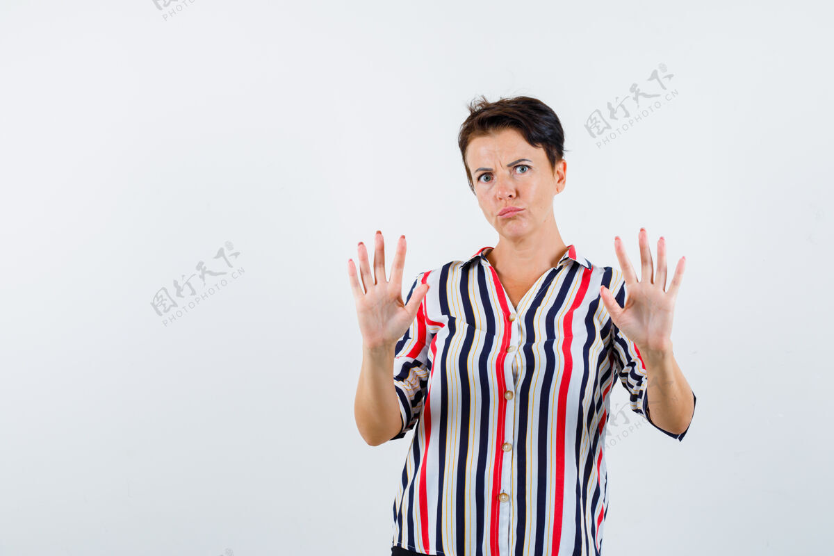 投降一个成熟的女人 穿着条纹衬衫 举手投降 看起来很害怕正视图健康提高人
