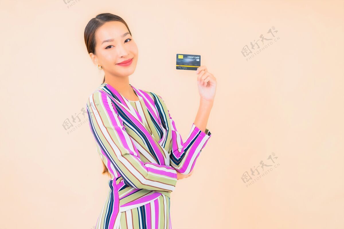 漂亮用智能手机和彩色信用卡描绘美丽的亚洲年轻女子银行成人钱