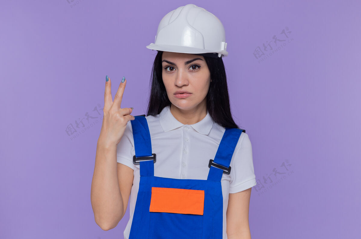 女人穿着施工制服和安全帽的年轻建筑工人建筑建筑工人严肃
