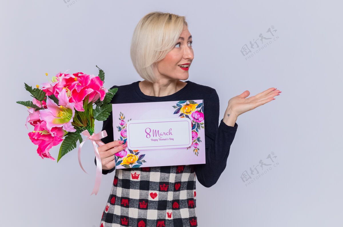 微笑快乐的年轻女子手持贺卡和花束 面带微笑地向一旁献上礼物 庆祝国际妇女节三月介绍衣服站立
