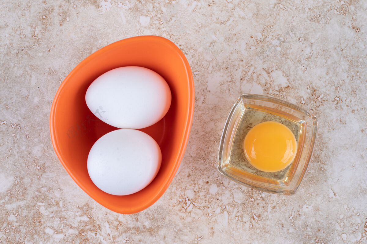 生的一个橙色的碗 里面有新鲜的白鸡蛋新鲜未经烹调的蛋黄