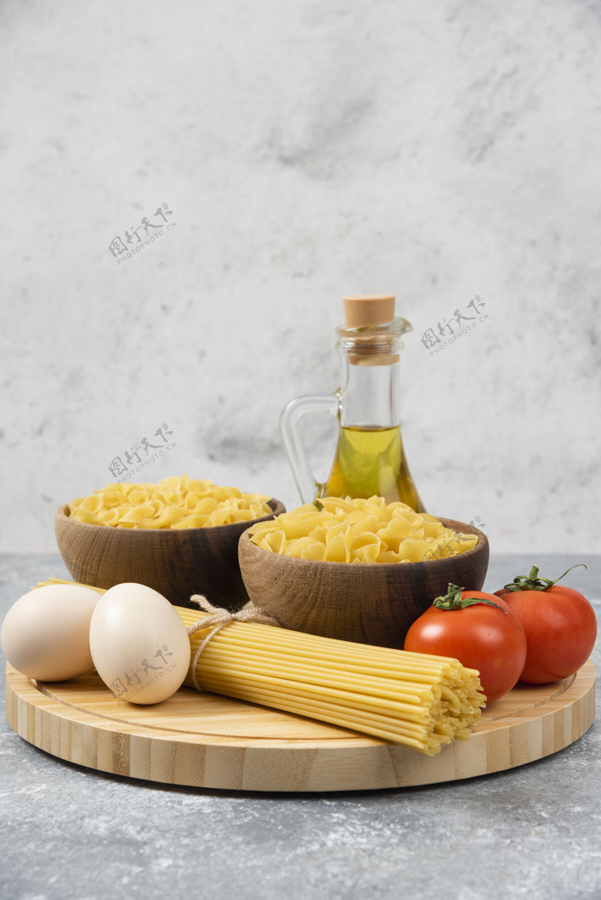 面食在大理石表面放上几碗生意大利面 鸡蛋 西红柿和橄榄油生的意大利面鸡蛋