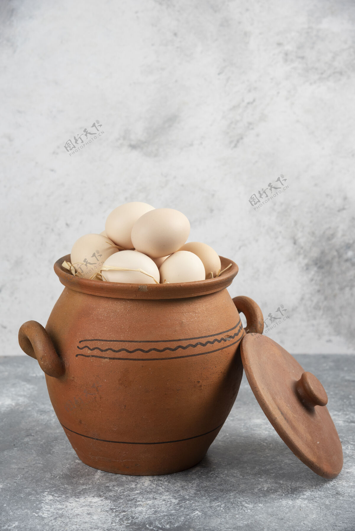 有机装满生鸡蛋的泥锅放在大理石上食品生的生的