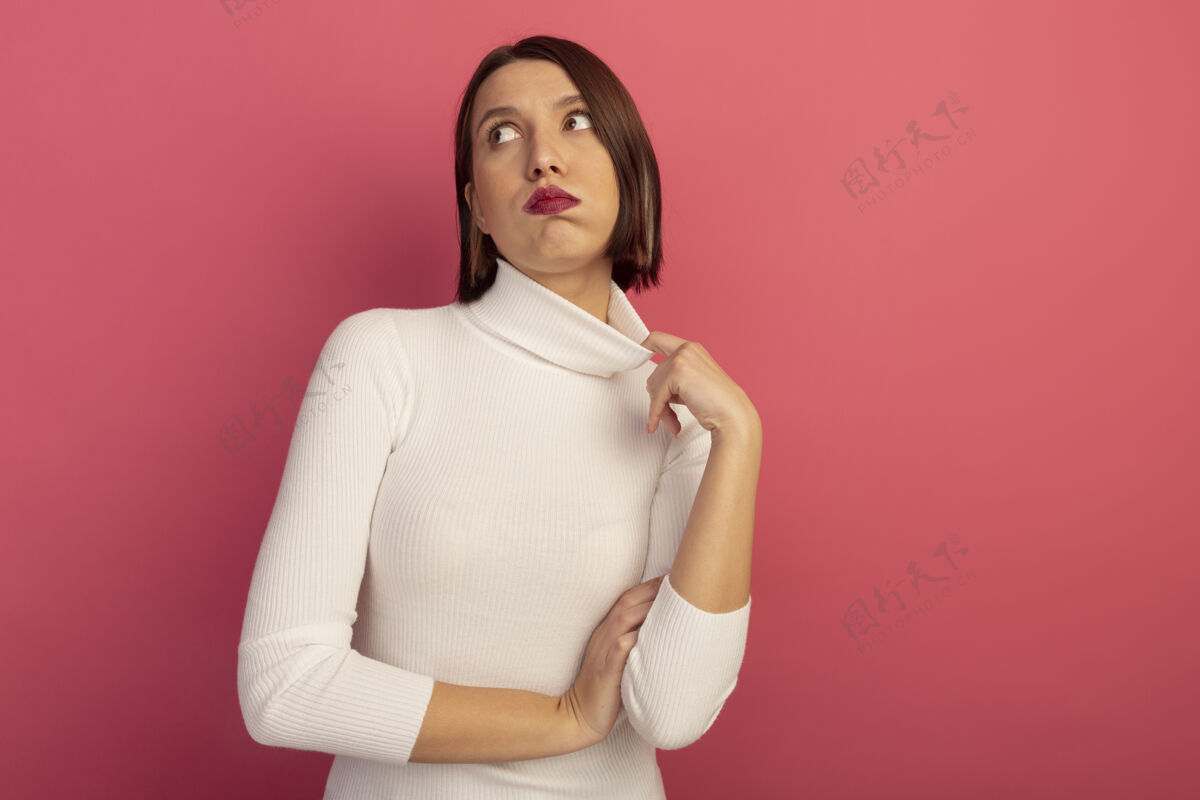 人恼羞成怒的美女拉着衣领看着隔离在粉红色墙上的一面人女人感觉