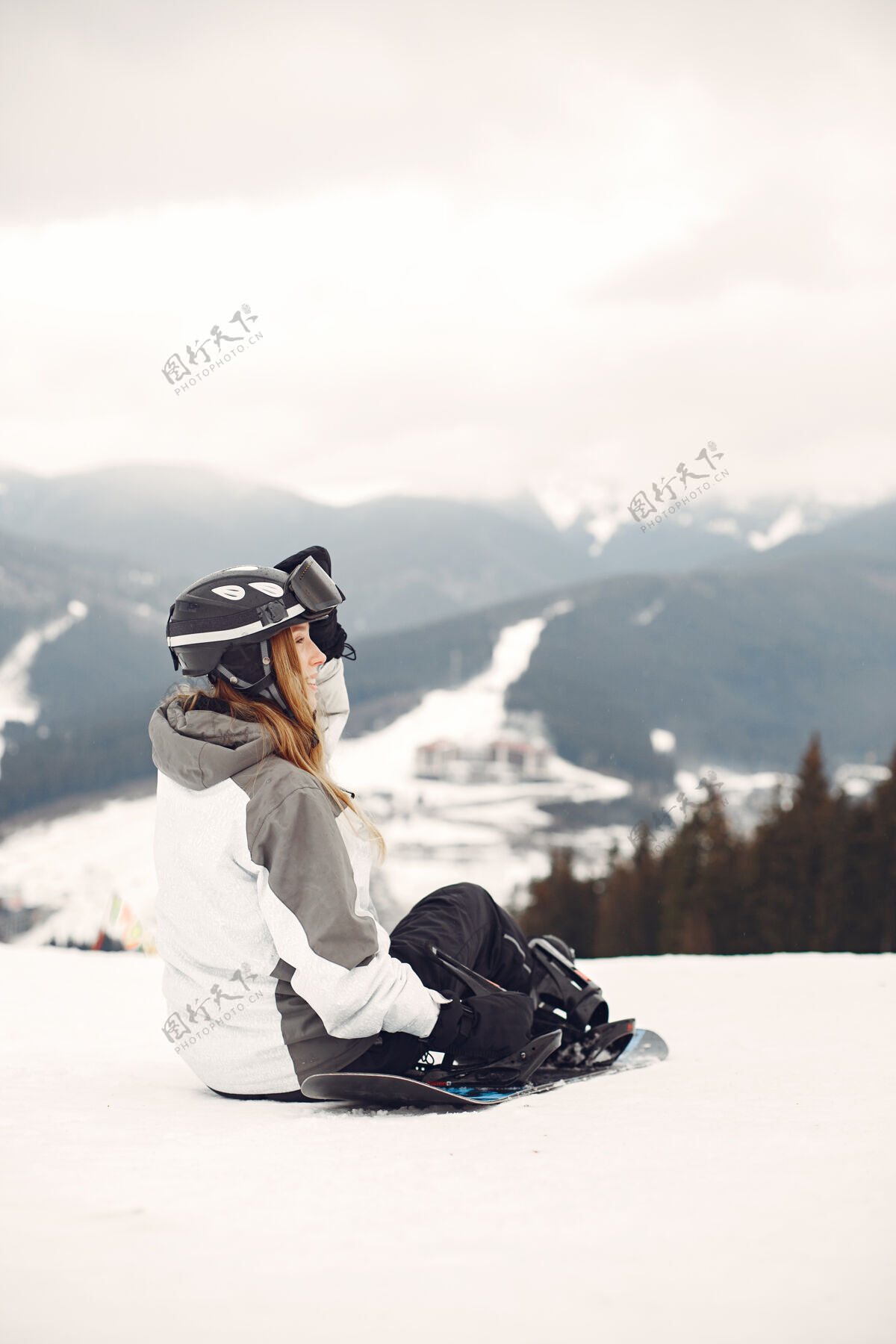 运动服穿着滑雪板套装的女人在山上手拿滑雪板的运动员在地平线上关于运动的概念娱乐女孩板