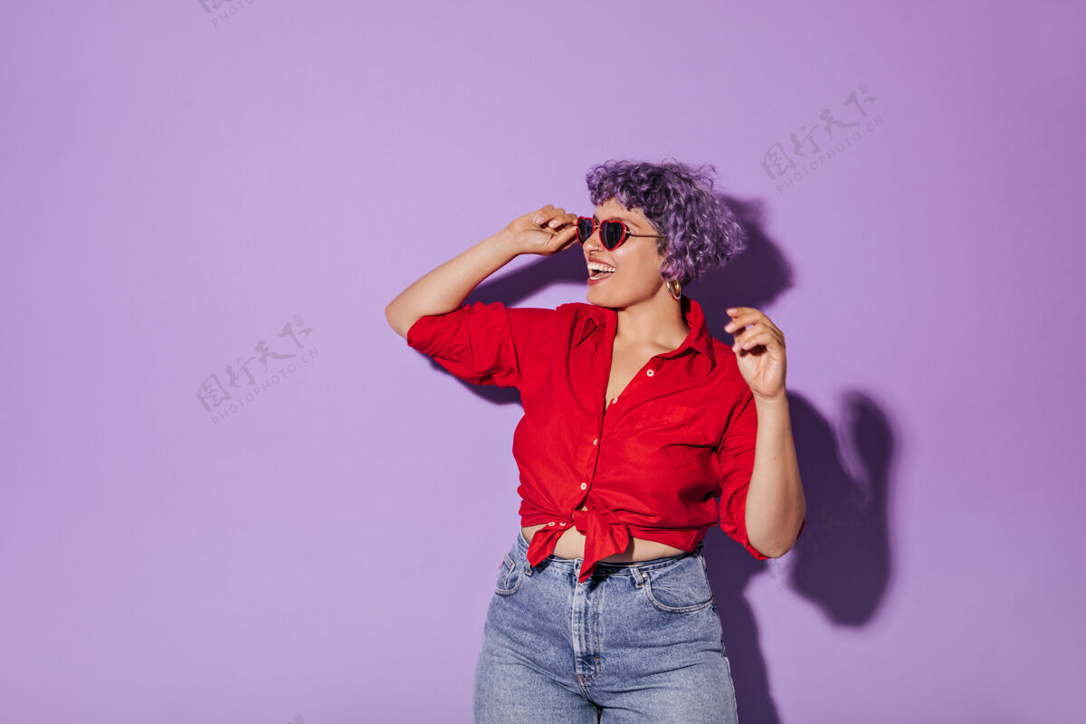 女人一头短发的女人 紫色短发 穿着时髦的衣服 微笑着 戴着墨镜站在孤立的丁香花上肖像脸休闲