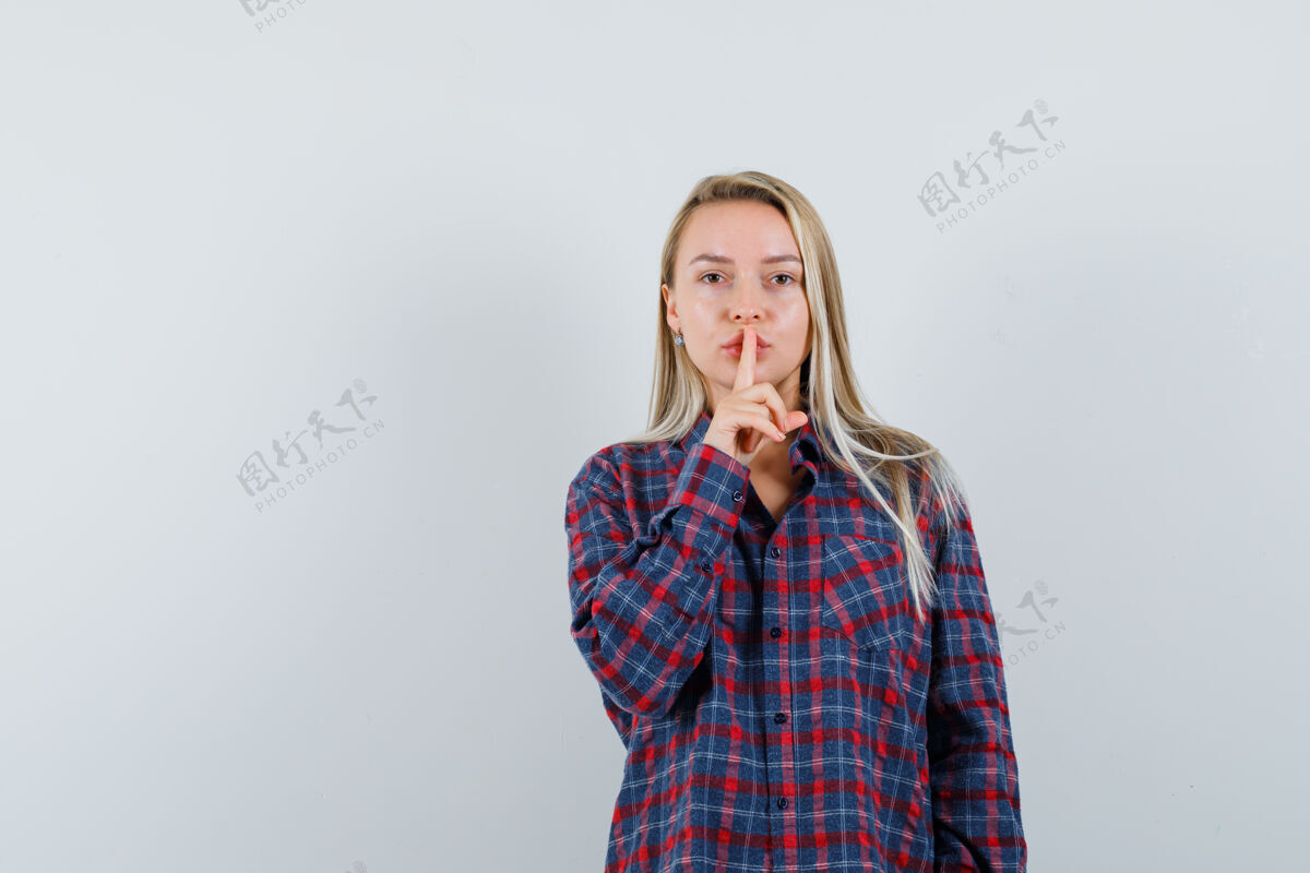 沉默穿着格子衬衫的金发女人把食指放在嘴上 表现出沉默的姿态 看起来很有吸引力 正面视图皮肤衬衫目录