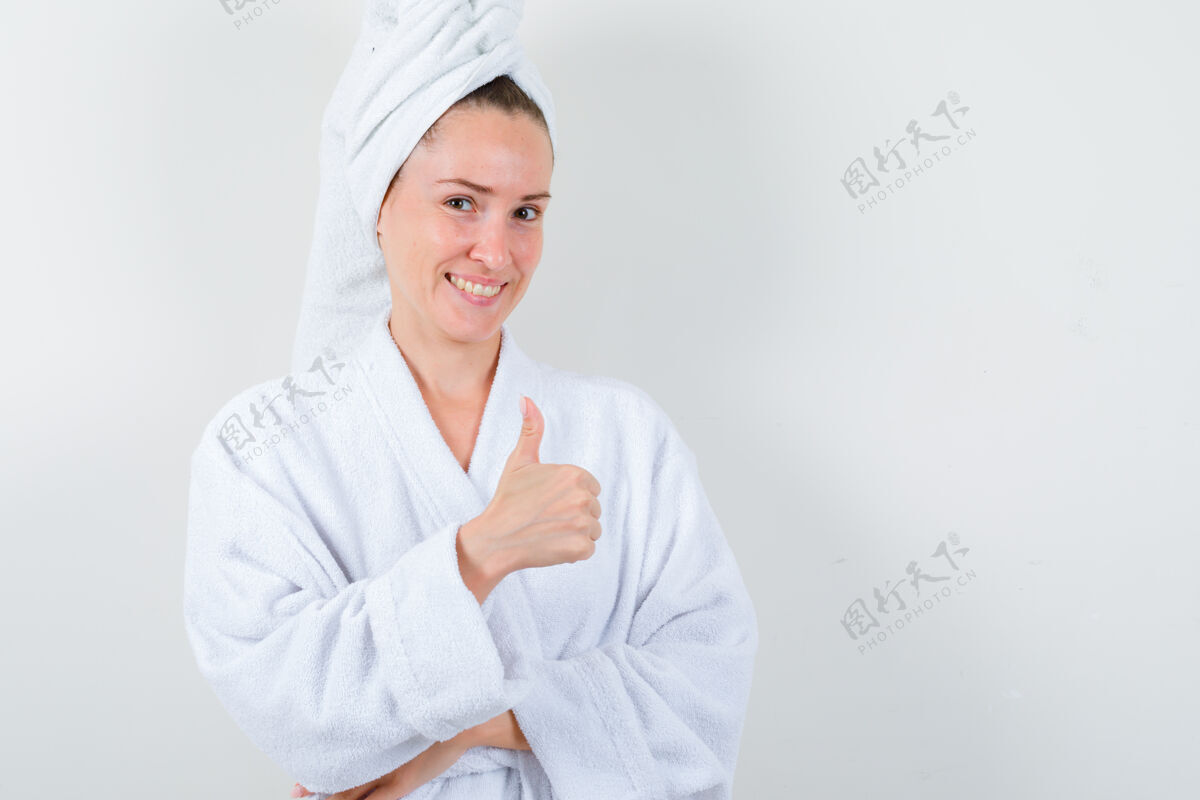 女孩穿着白色浴衣 毛巾的年轻女士竖起大拇指 看上去很快乐正视图清洁自然新鲜