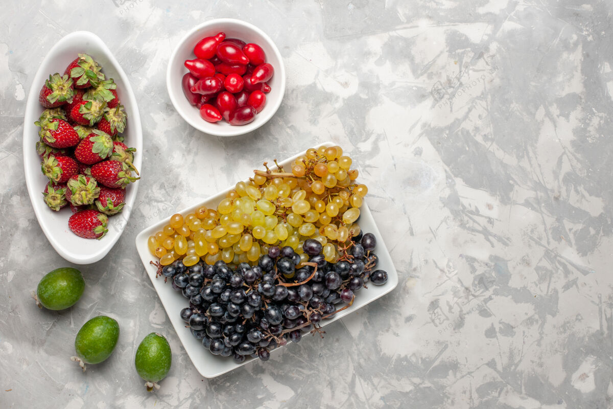 新鲜顶视图新鲜葡萄与草莓和山茱萸在白色的表面水果醇厚的维生素果汁蔬菜晚餐果汁