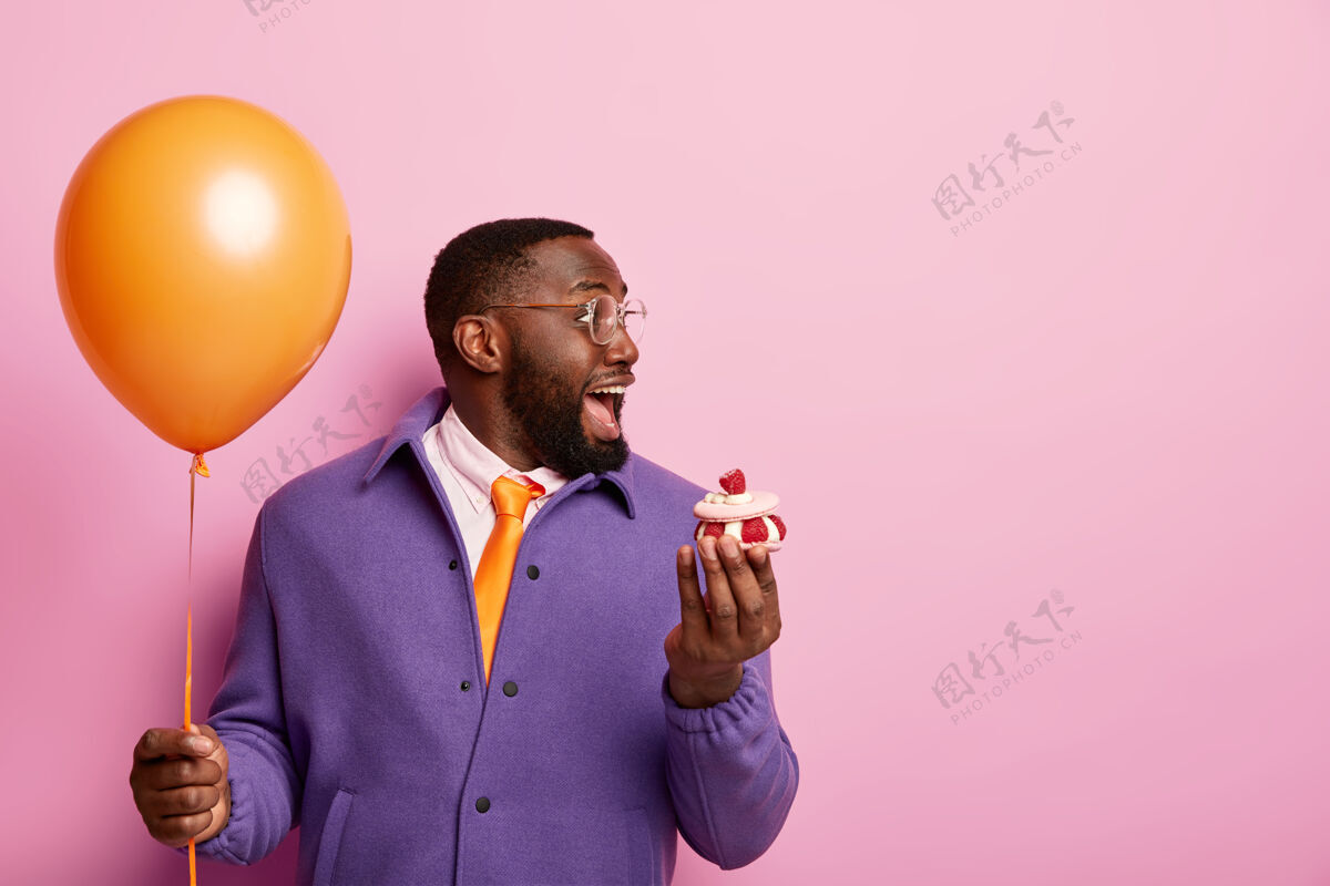 青少年快乐震惊的美国黑人男子站在派对气球和甜点胡须高兴奇迹