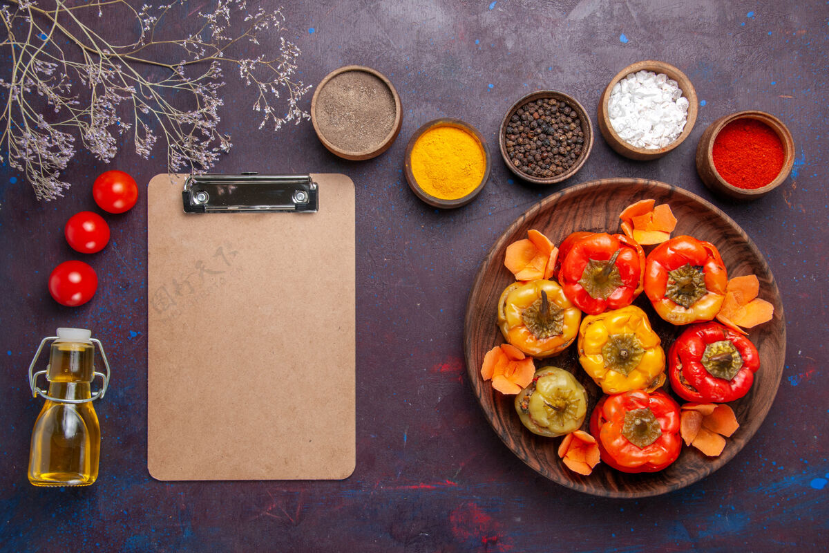 生的顶视图煮熟的甜椒与不同的调味料对深灰色桌上餐蔬菜肉多尔玛食品甜椒桌子盘子
