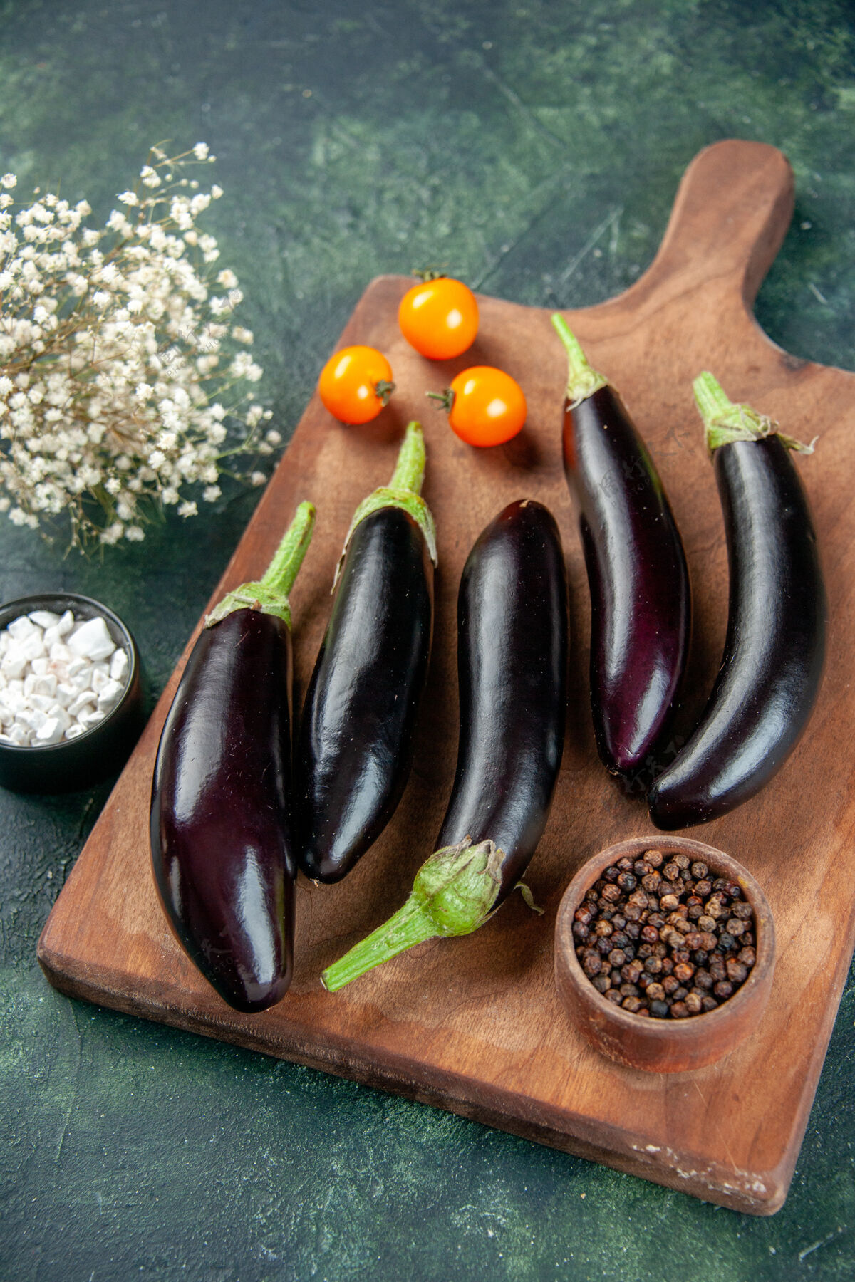 烹饪上图：黑色茄子在砧板上深色的背景茄子一餐胡椒