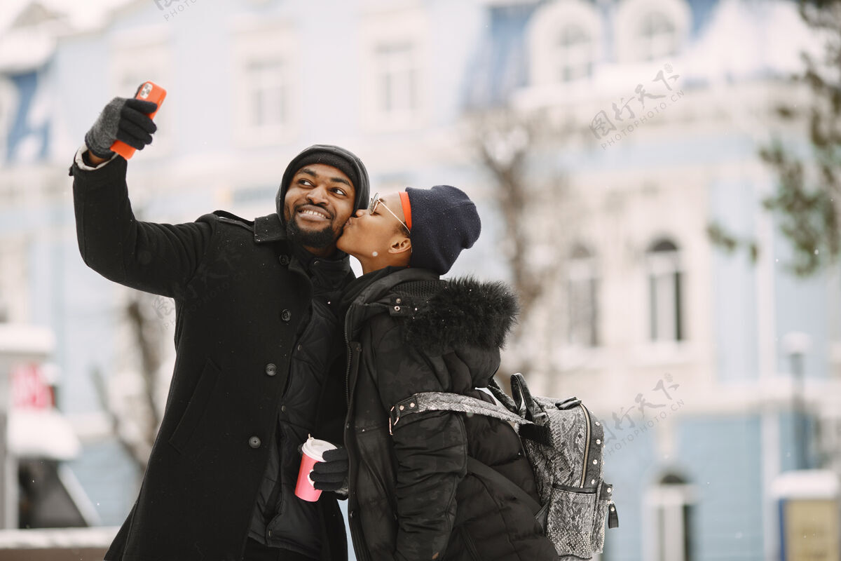 情侣人们走在外面冬天非洲夫妇喝着咖啡下雪自拍美国