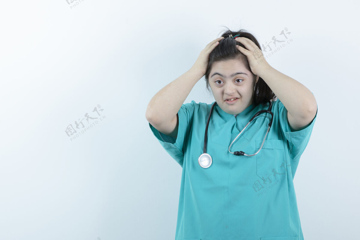 唐氏综合症年轻的女护士用听诊器对着白墙摆姿势女性人担心