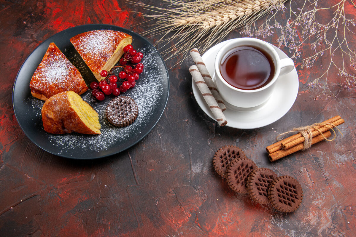 食物俯瞰美味的切片派与饼干和一杯茶在黑暗的桌子上甜甜的派蛋糕深色的茶碟咖啡因