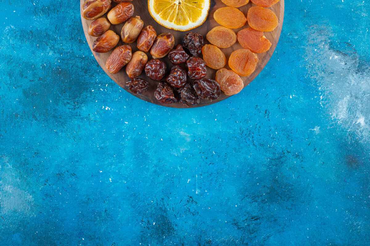板子把柠檬和干果切片放在蓝色的板上美味干果美味