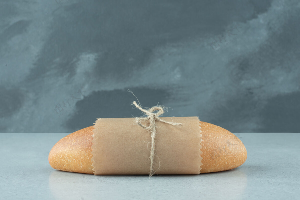 新鲜新鲜面包卷用绳子绑在石头表面卷面包房整个