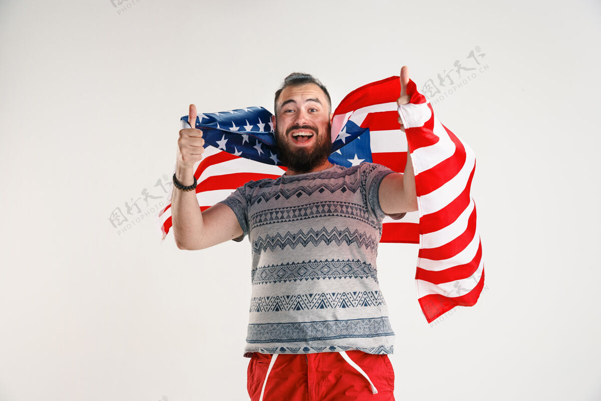 白天拿着美国国旗的年轻人男性美国男人