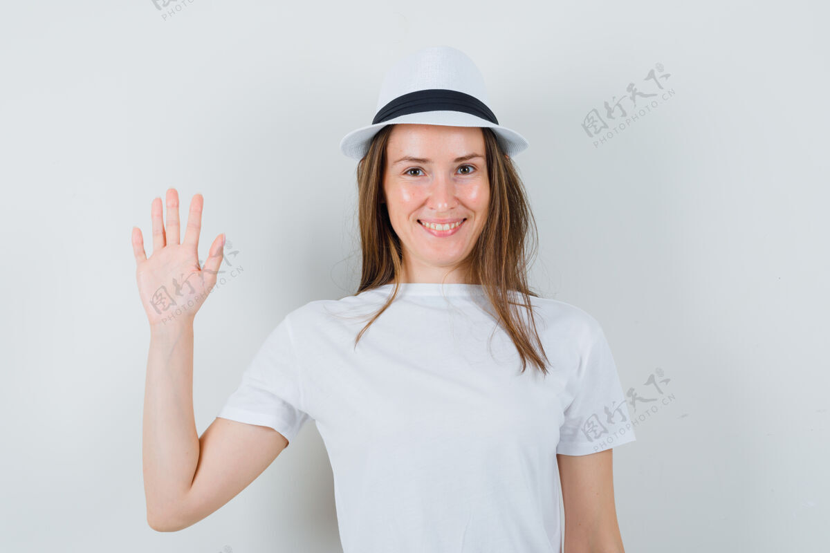时尚年轻的女士挥手告别 戴着白色的t恤帽子 看上去很高兴女士黑发休闲