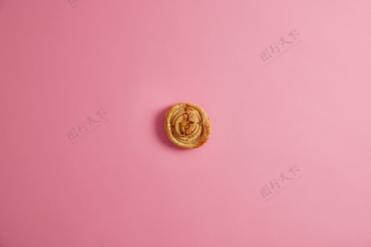 芳香新鲜的家庭烤螺旋面包 为您的美味早餐 以满足您的甜食开胃的美味糕点含有大量热量 照片从上方的粉红色背景芳香的甜点圆形风味面粉