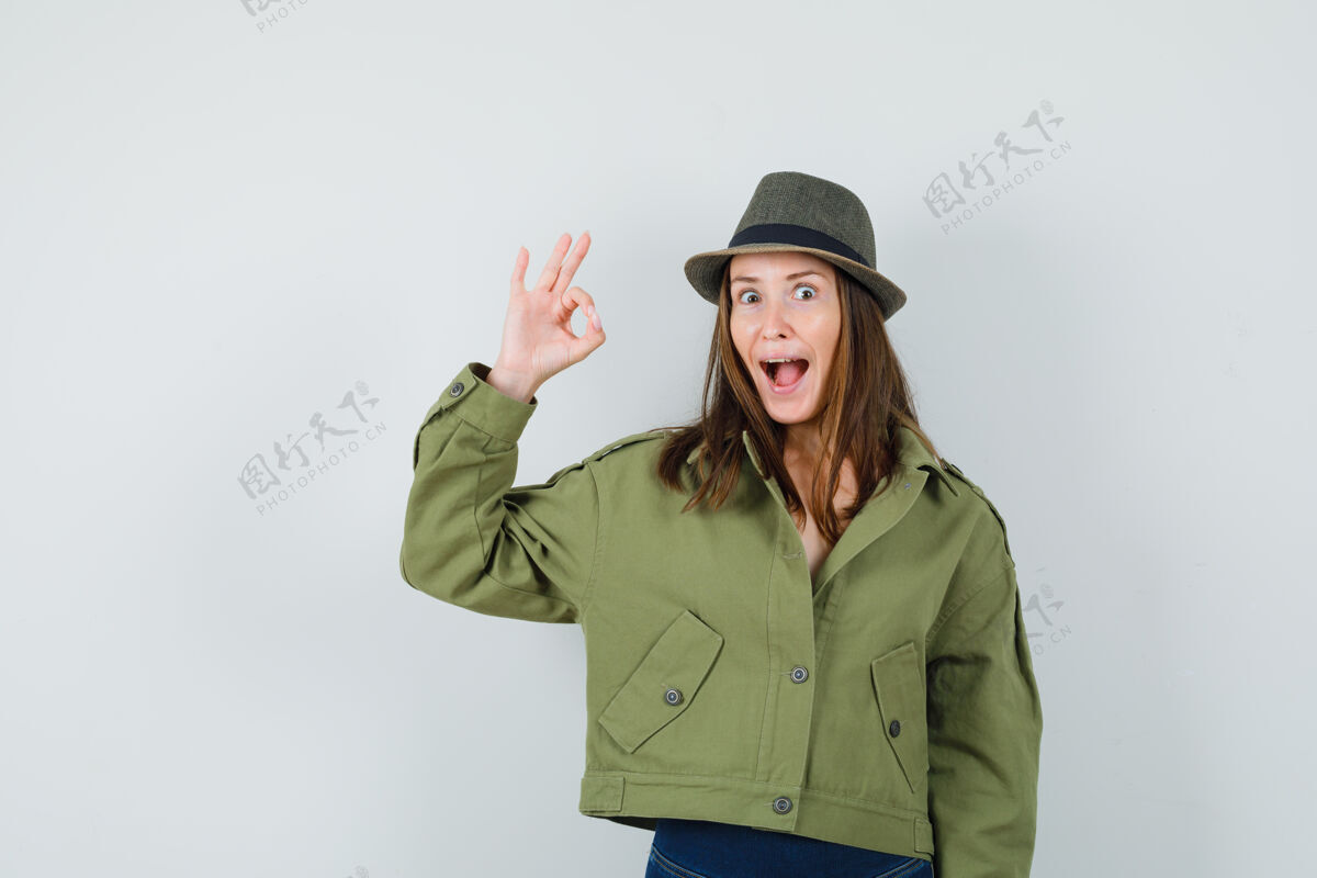 时尚年轻女士穿着夹克 戴着裤子 戴着帽子 看起来很开心姿态正面夹克