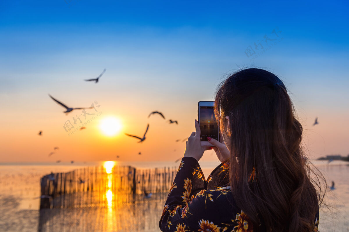 瑜伽鸟儿在飞翔 年轻女子在日落时拍照信仰表达和平