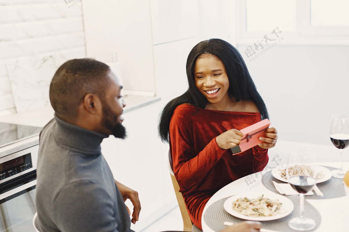 周年纪念情人节这天 一对夫妻坐在桌旁 吃饭 谈笑风生非洲裔家庭节日