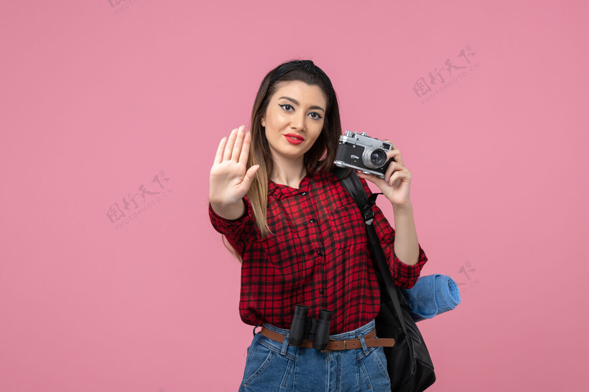 衬衫正面图：穿着红色衬衫的年轻女性 在粉色办公桌上用相机拍照的女性模特成人年轻女性漂亮
