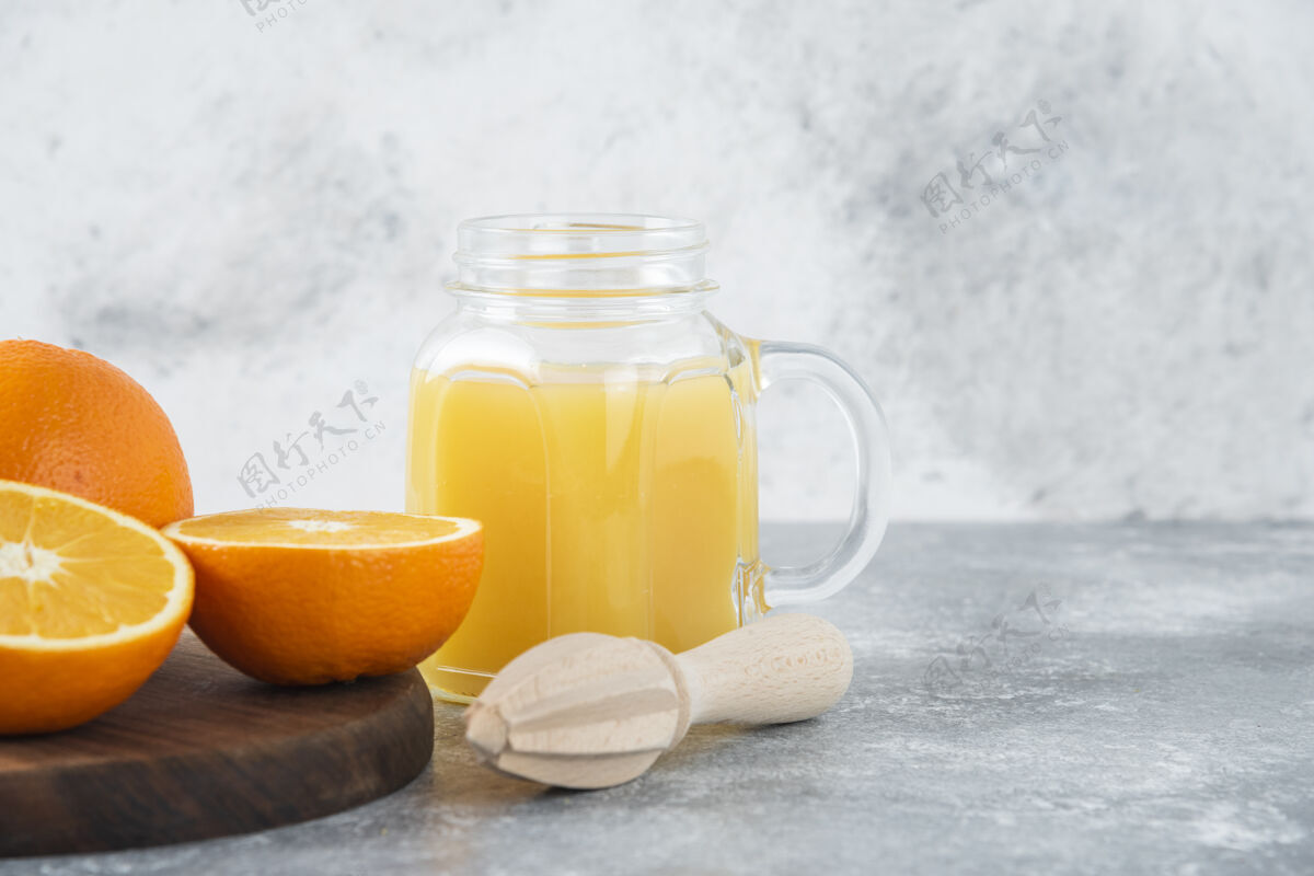 橙子石桌上放着一杯果汁和新鲜的橙子圆形美味热带