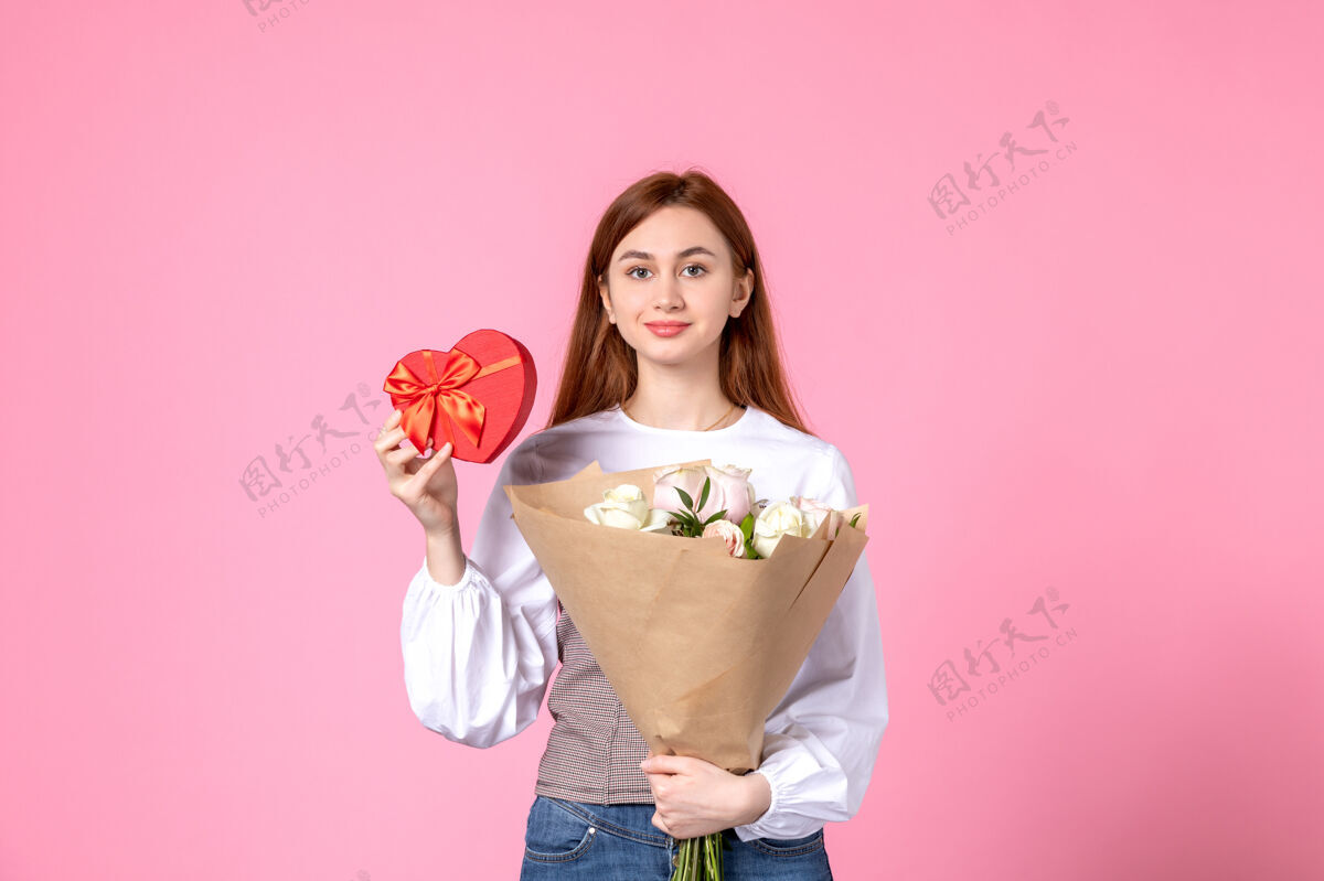 礼物正面图：年轻女性 带鲜花 作为女性节礼物 粉色背景 水平三月 女性约会 平等玫瑰 爱情 性感 女性化礼物年轻女性玫瑰