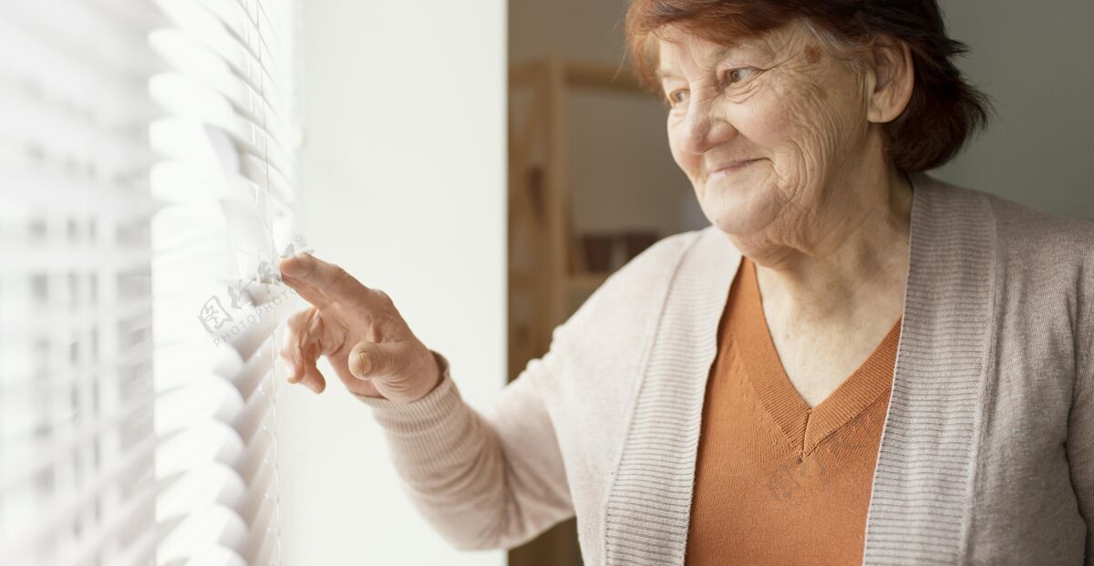 女人特写镜头女人看着窗外退休之家老年人生活方式