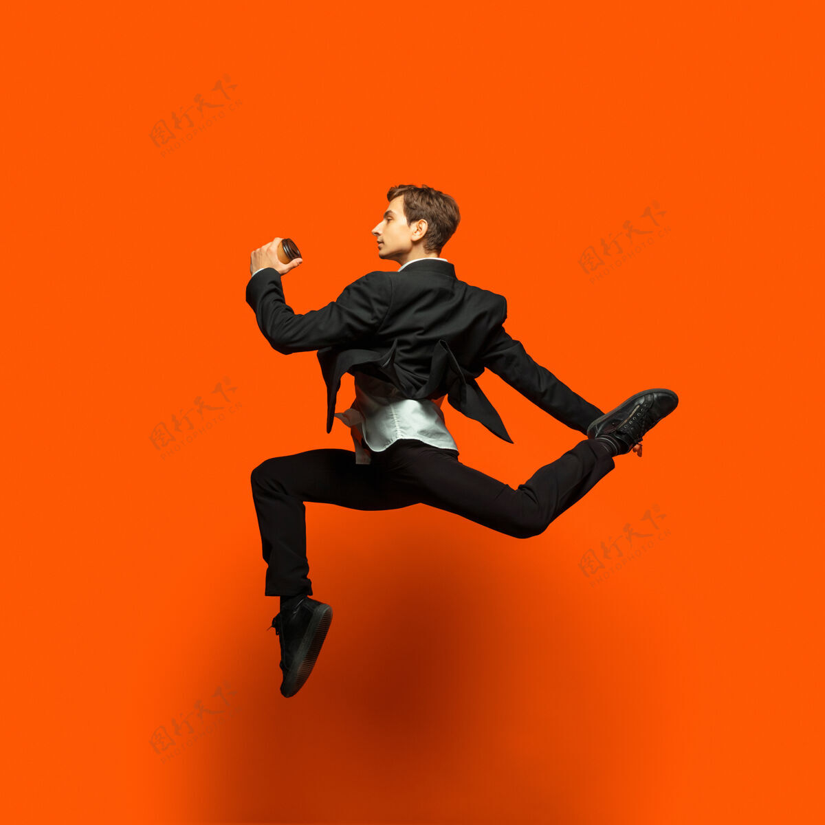 工作穿着休闲办公服的男人在明亮的橙色上跳啊跳啊跳啊公司欢乐西装