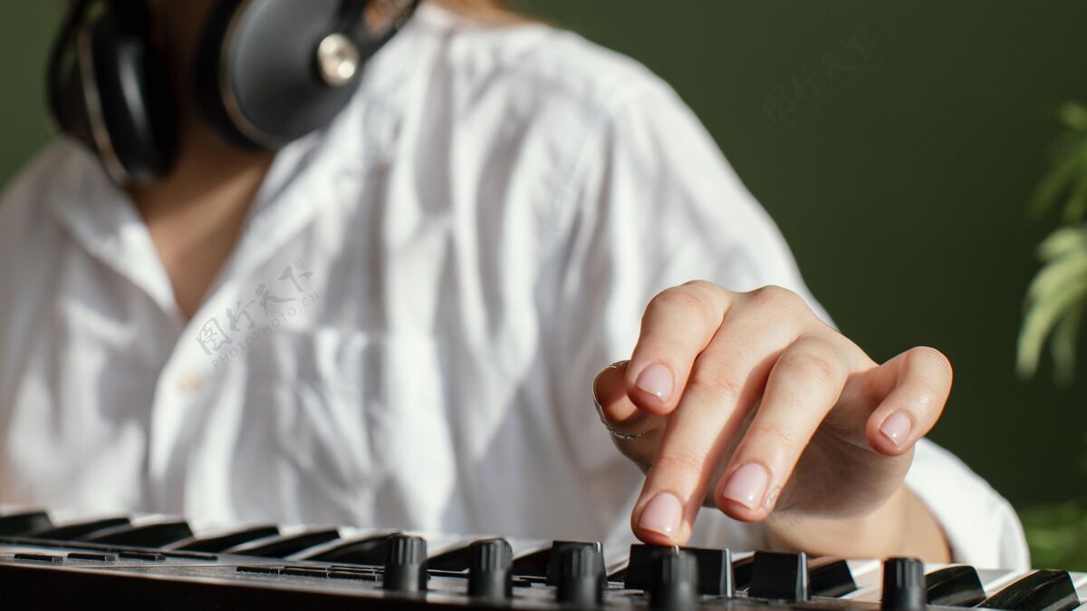 声音特写镜头的女音乐家与钢琴键盘和耳机在室内乐器钢琴键盘家用