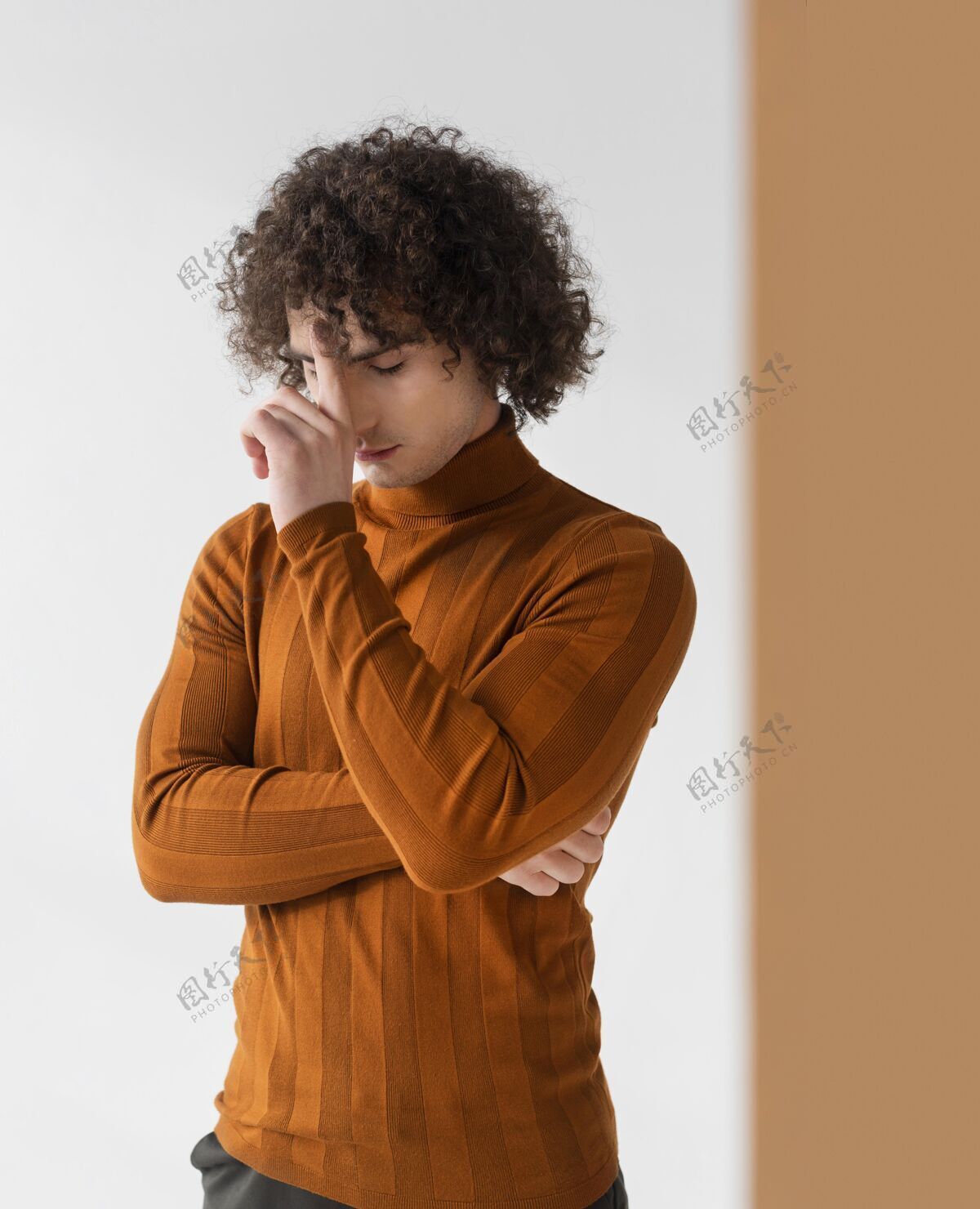 男人卷发男人穿着棕色衬衫摆姿势时尚摆姿势年轻