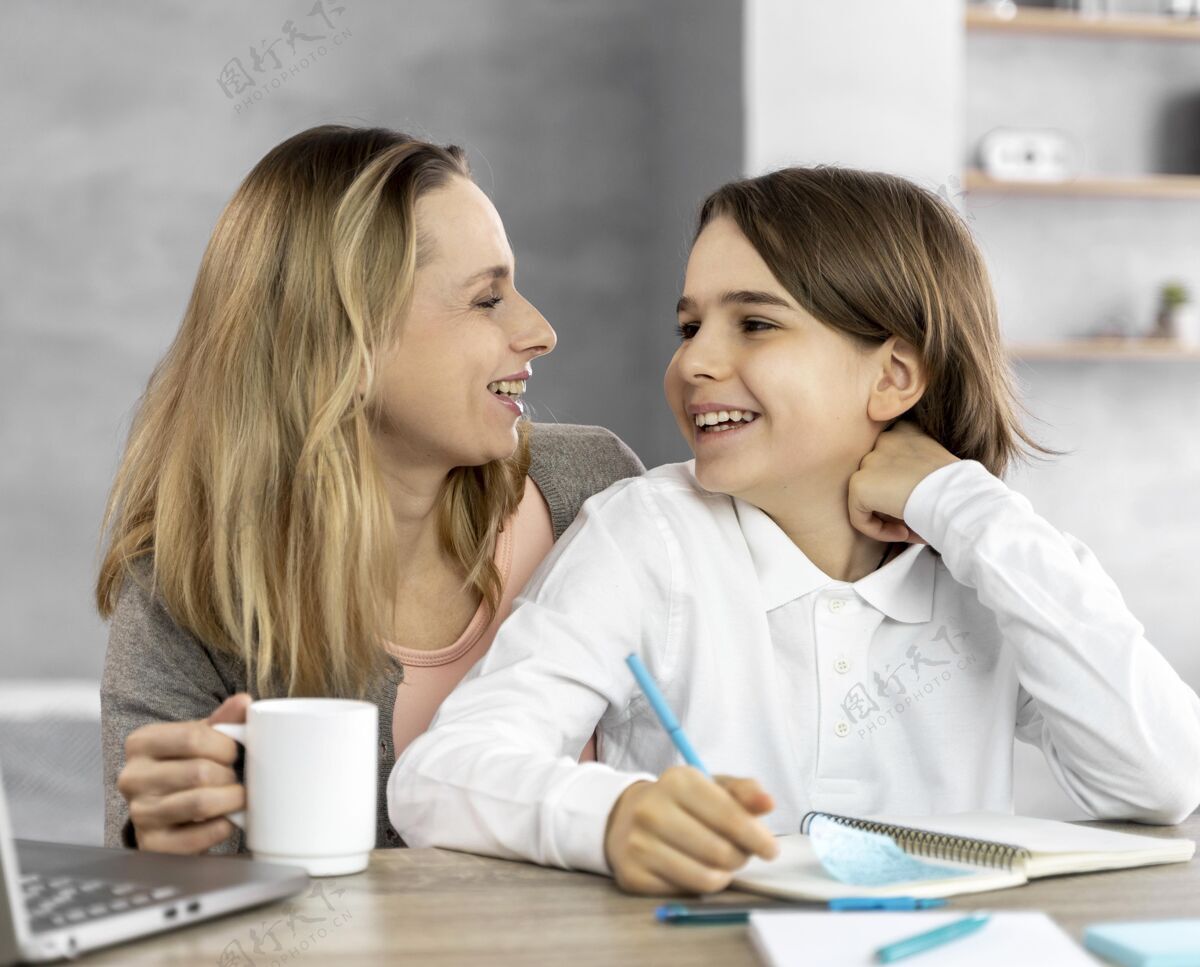女人妈妈帮助女儿学习设备笔记本电脑学习