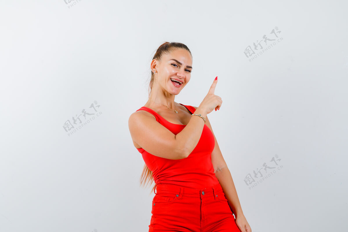 女人穿红色单品的年轻女士 红裤子朝上 看起来很快乐 正前方的景色健康裤子完美