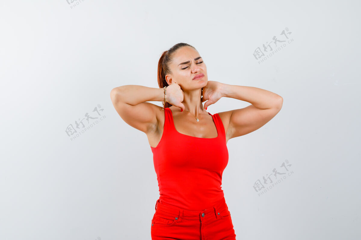 女人穿红色单品的年轻女士 脖子酸痛的红裤子 看起来很痛苦 正面图年轻压力头痛