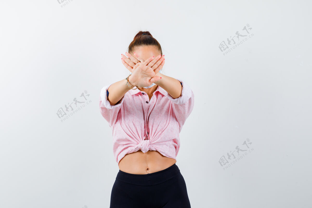 漂亮照片中的年轻女性穿着衬衫 裤子 戴着面具 表情坚定地站在前面前面时尚手势