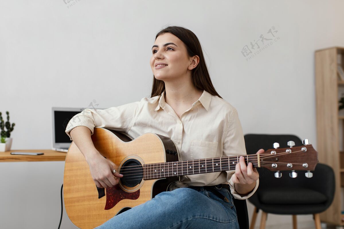 室内笑脸女音乐家弹原声吉他前视图吉他乐器水平