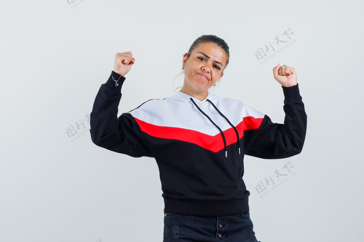 显示穿着五颜六色运动衫的年轻女士展示了她的手臂力量和自信 正面视图前面女士女性