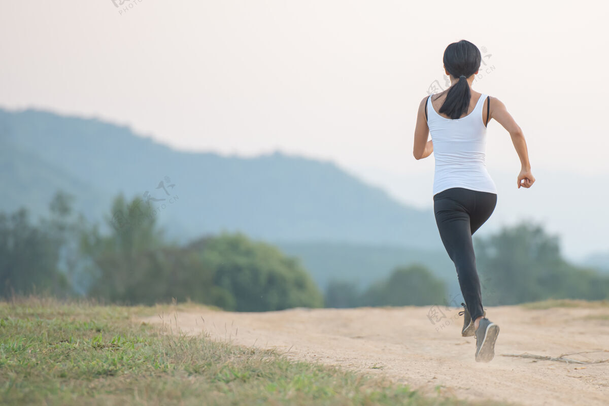跑步年轻的女士享受着健康的生活方式 一边沿着乡村公路慢跑 一边在户外锻炼和健身亚洲人中国身体