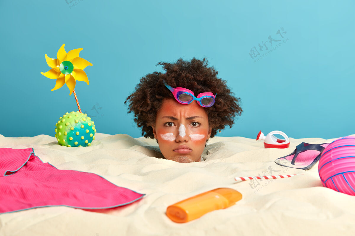 照片年轻女子头上涂着防晒霜 脸上围着沙滩饰品卷发红色应用